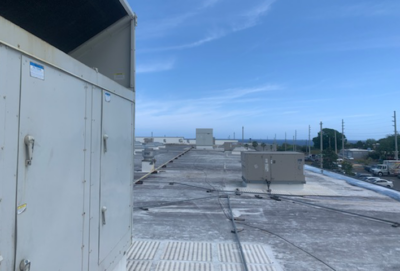 Rooftop view with multiple HVAC units under a clear blue sky.